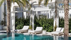 A pool area with lounge chairs and palm trees. - A Welcoming Space for Your Next Vacation! Onsite Pool, Free Parking! (Walton County)