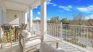 A covered outdoor area with a table and chairs, a white railing, and a view of the surrounding landscape. - A Welcoming Space for Your Next Vacation! Onsite Pool, Free Parking! (Walton County)