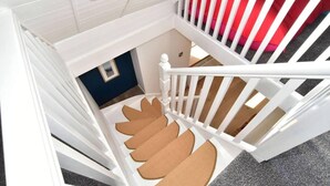 A white staircase with a unique spiral design leading to a lower level. - 2bed Cottage Johnshaven - Family Friendy (Montrose)