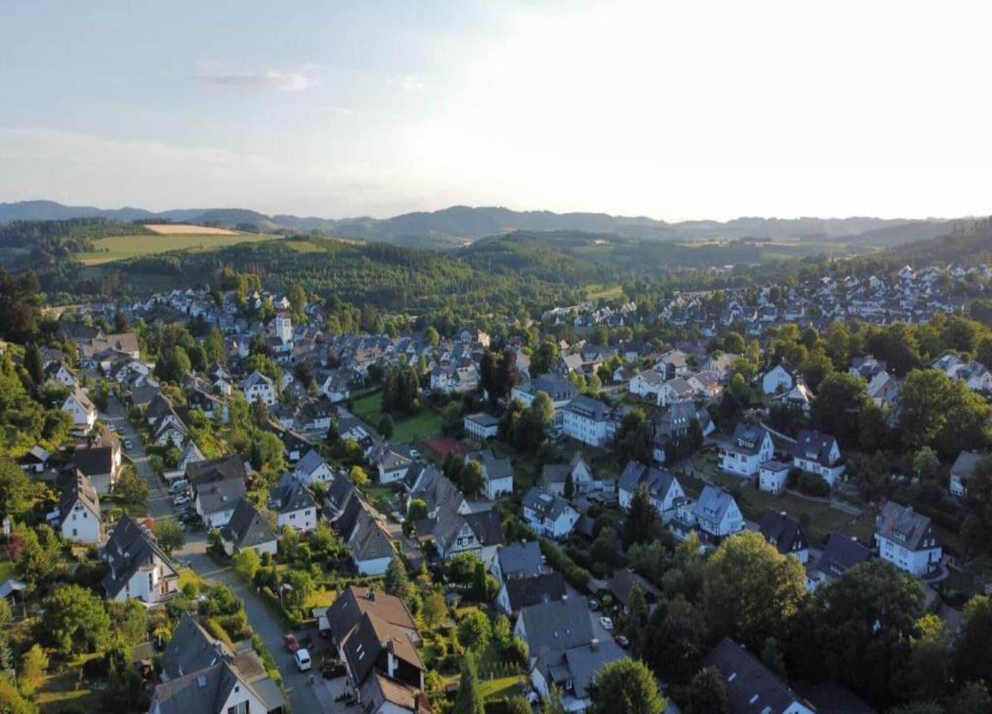A residential area with houses, roads, and surrounding greenery.