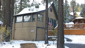 A wooden cabin with a sloped roof, a small porch, and an American flag. - All Seasons Chateau (Big Bear Lake)