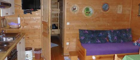 A cozy cabin with a kitchenette, a sofa, and a small dining table.