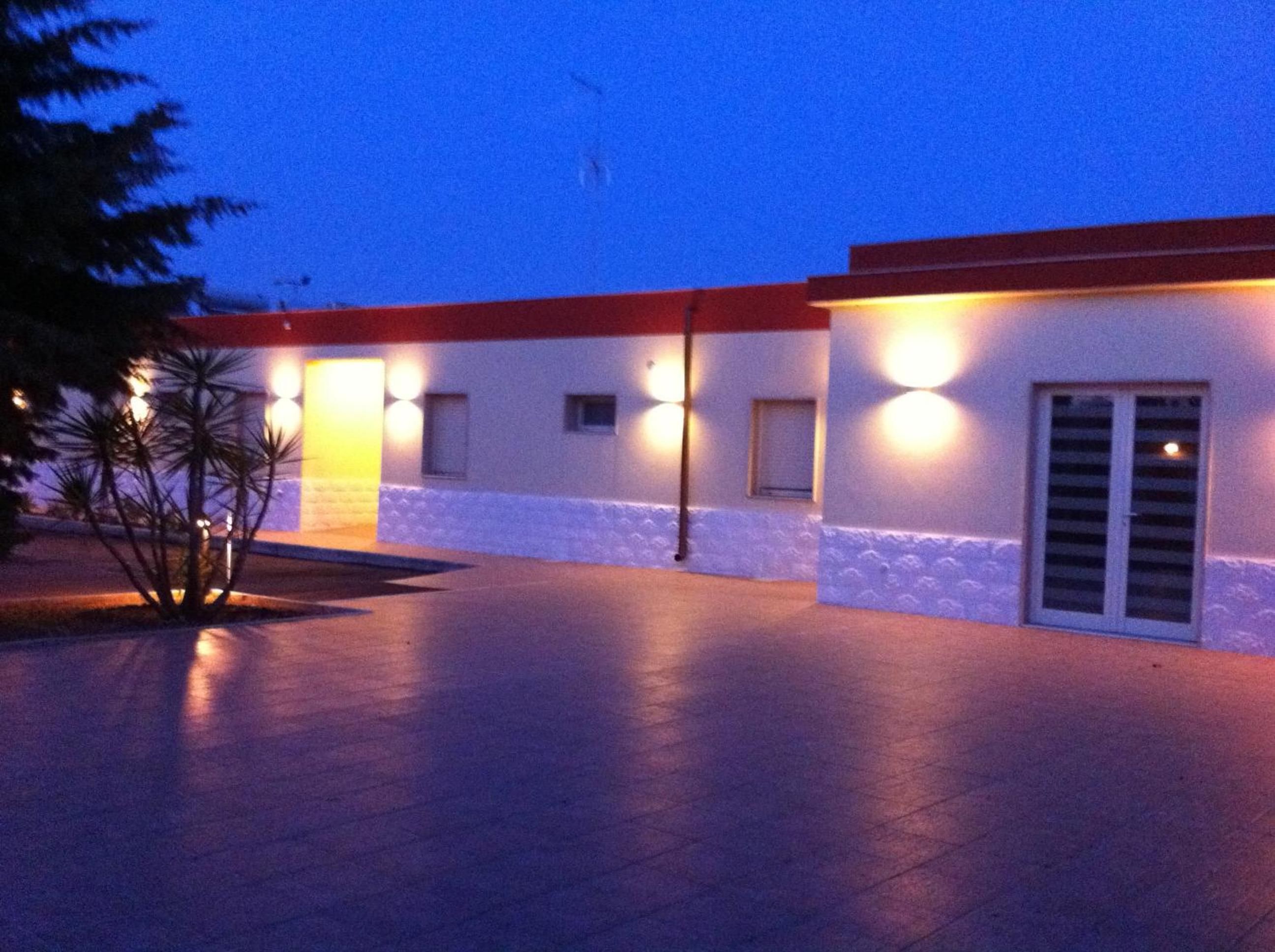A building with a flat roof, multiple windows, and a paved entrance area.
