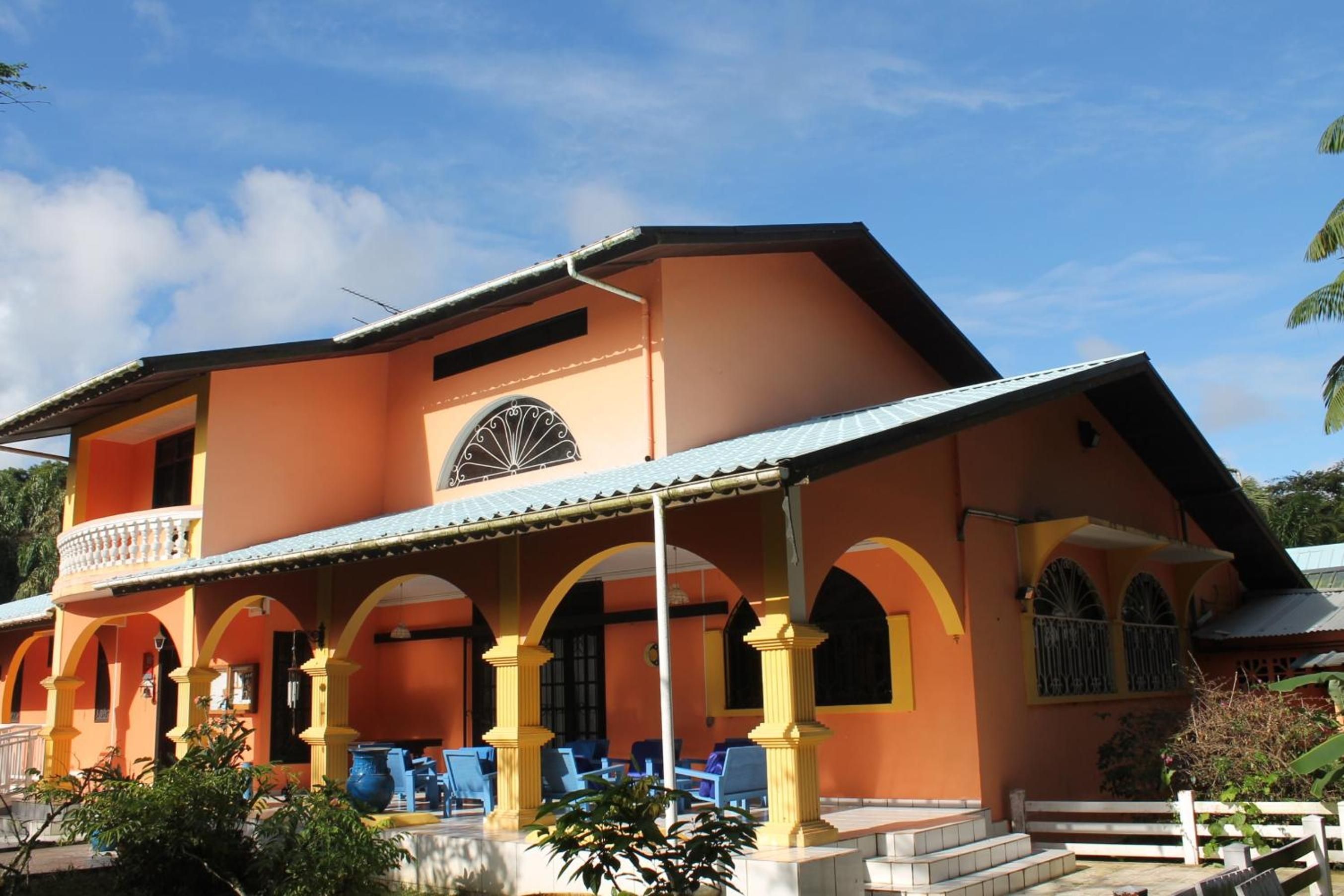 A two-story building with a balcony and a covered patio area.