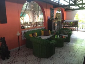 Una habitación con muebles de mimbre, un acuario y un arco decorativo.