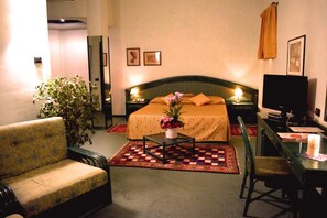 A hotel room with a bed, a desk, a chair, a television, and a potted plant. - Antica Postumia (Vedelago)