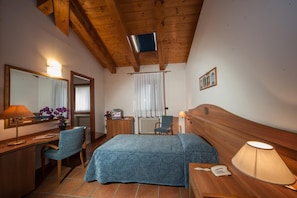 A hotel room with a bed, desk, chair, and a television mounted on the ceiling. - La Vigneta (Arsiero)