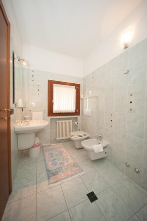 A bathroom with a toilet, bidet, sink, and a mirror. - La Vigneta (Arsiero)