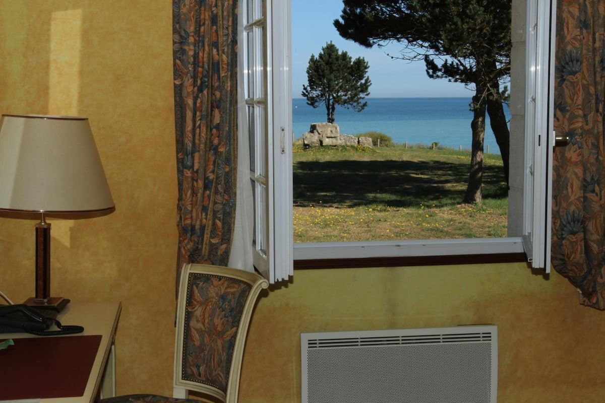 A room with a window, a lamp, a chair, and a radiator.