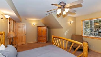 Quarto com cama, ventoinha no teto, guarda-roupa, janela com persianas e luminária.
