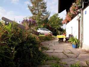 A stone pathway leading to a building with a car parked in the background. - Ferienhaus In Bayern Mit Waldblick (Viechtach)