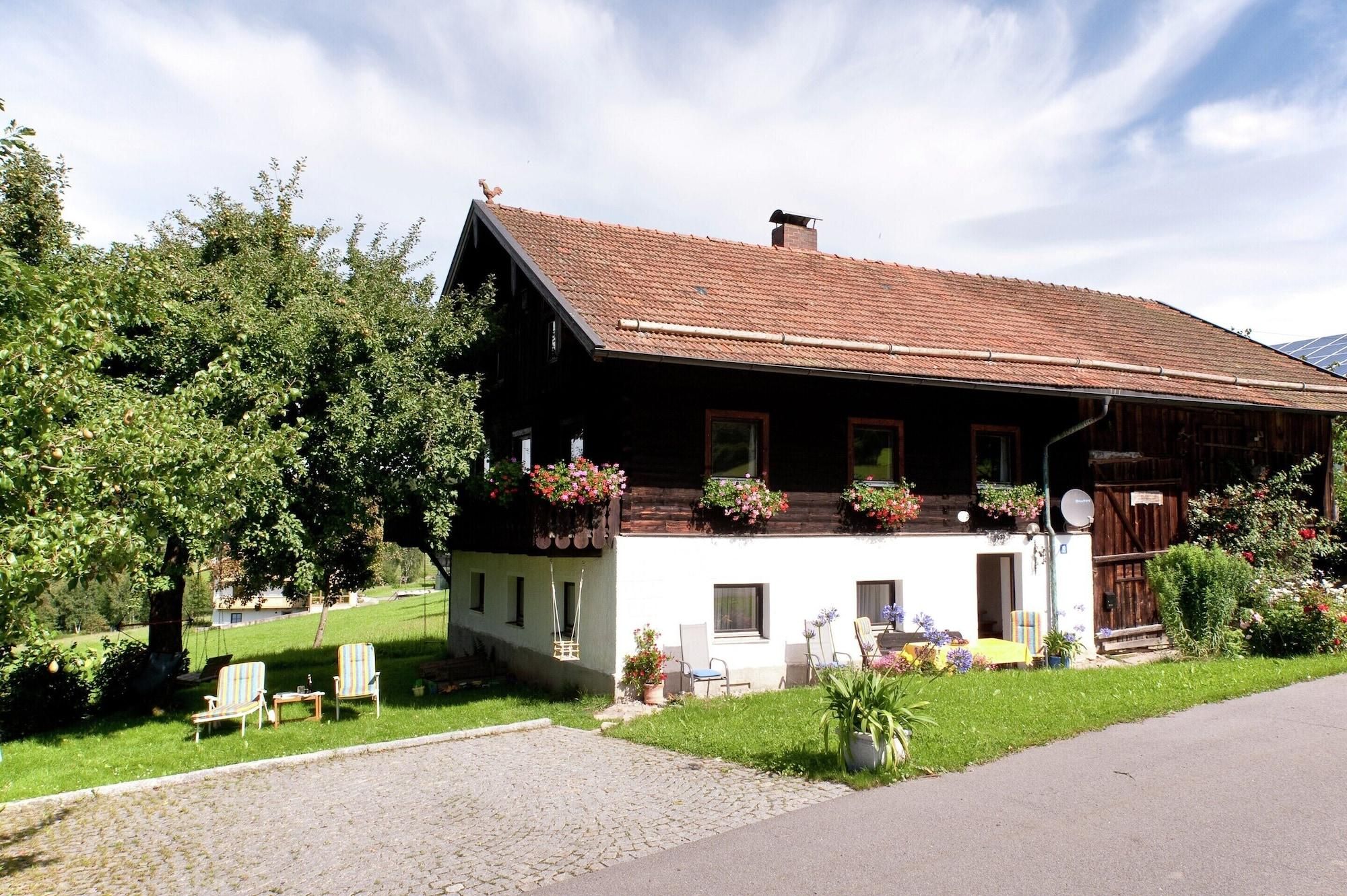 A traditional chalet with a sloped roof, wooden exterior, and flower boxes on the balcony.