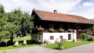 A traditional chalet with a sloped roof, wooden exterior, and flower boxes on the balcony.