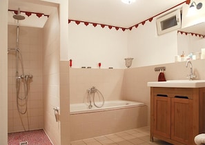 Un baño con ducha, bañera y armarios de madera.