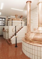 Una escalera con tuberías de cobre y una pared con azulejos.
