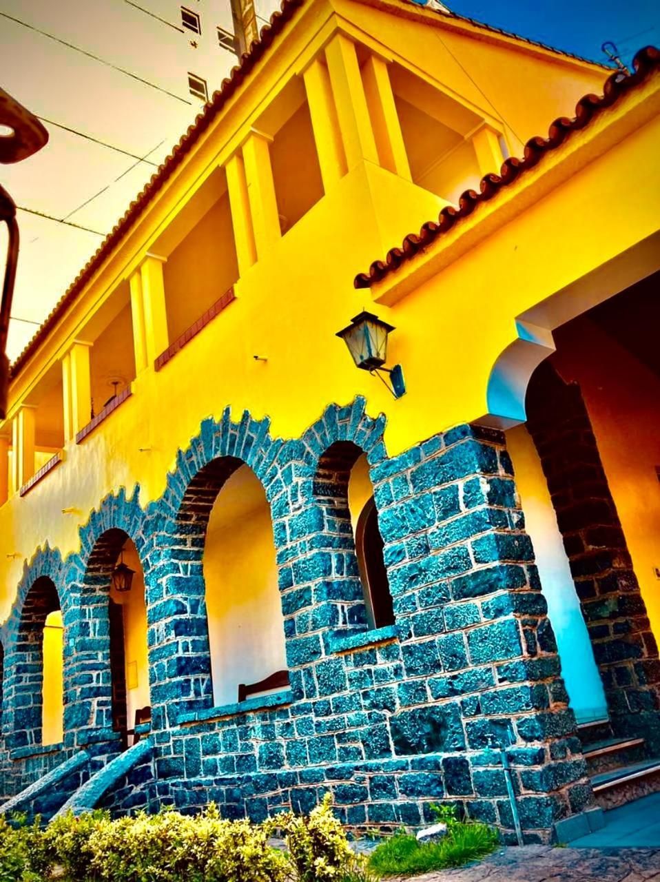 A building with yellow walls and blue stone arches.