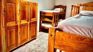 A room with wooden bunk beds and a large wooden wardrobe.