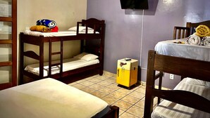 A room with bunk beds, a television mounted on the wall, and a small refrigerator.