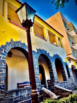 A building with a yellow facade, blue patterned arches, and a street lamp.