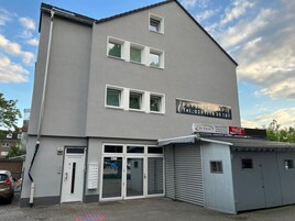 A building with a sign for a physiotherapy clinic, a Coca-Cola sign, and a City Kiosk.