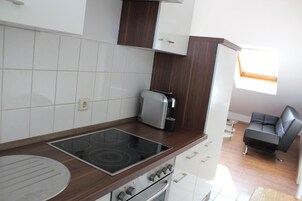 A compact kitchen with a built-in stovetop, oven, and a small window.