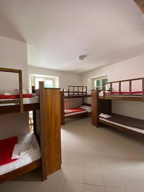 A dormitory room with bunk beds, a window, and a radiator. - Ostello Voltaggio (Voltaggio)