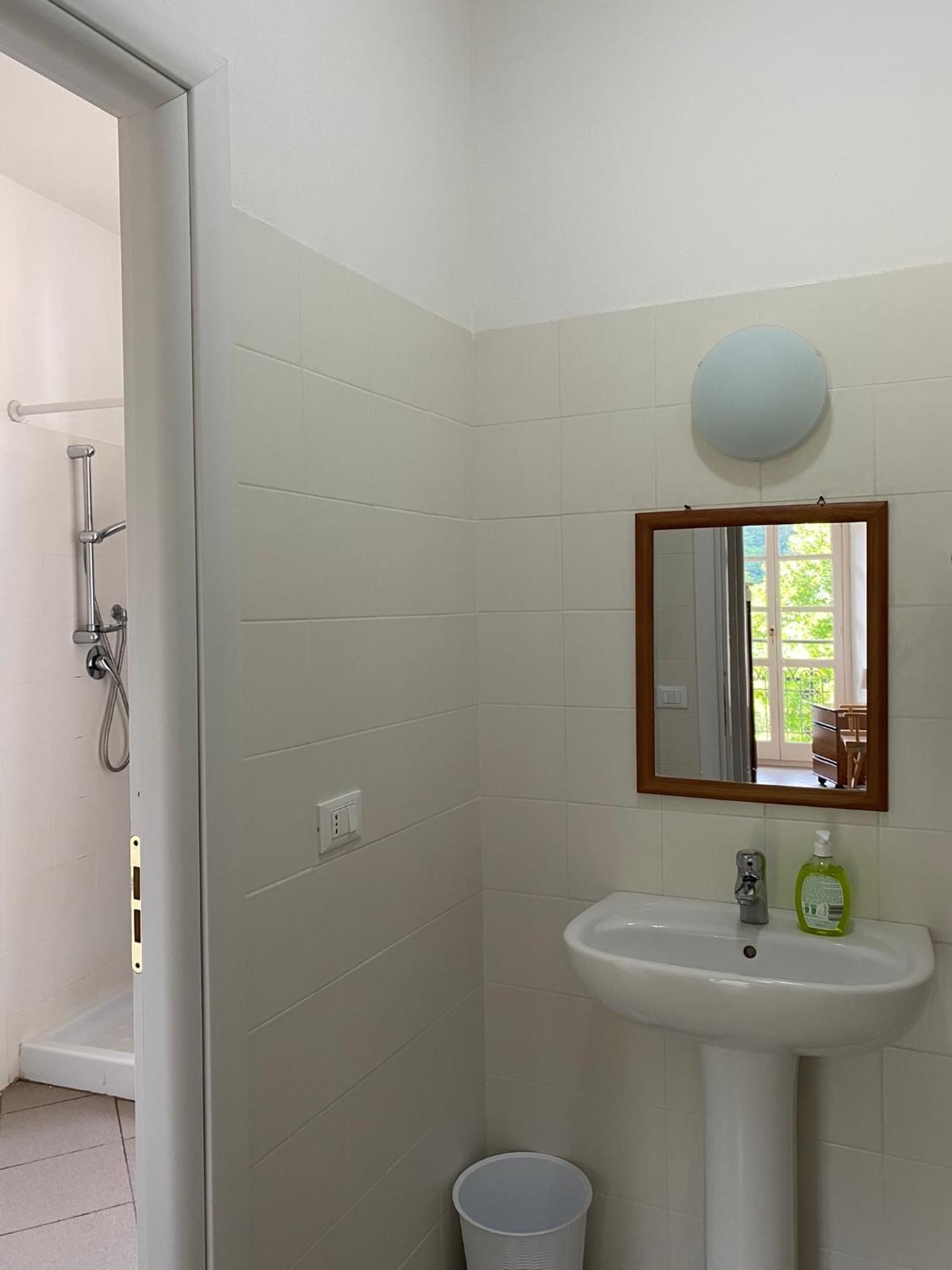 Une salle de bain avec un lavabo blanc, un miroir et un espace douche.