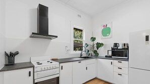 A modern kitchen with white cabinets, a stove, oven, and a microwave.