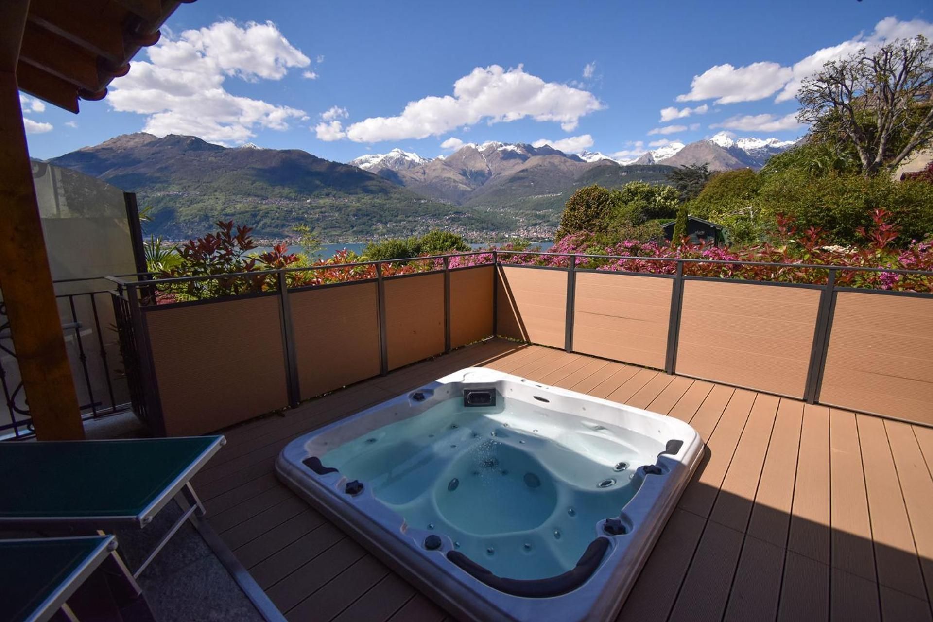 Un bain à remous sur une terrasse en bois avec vue sur les montagnes.