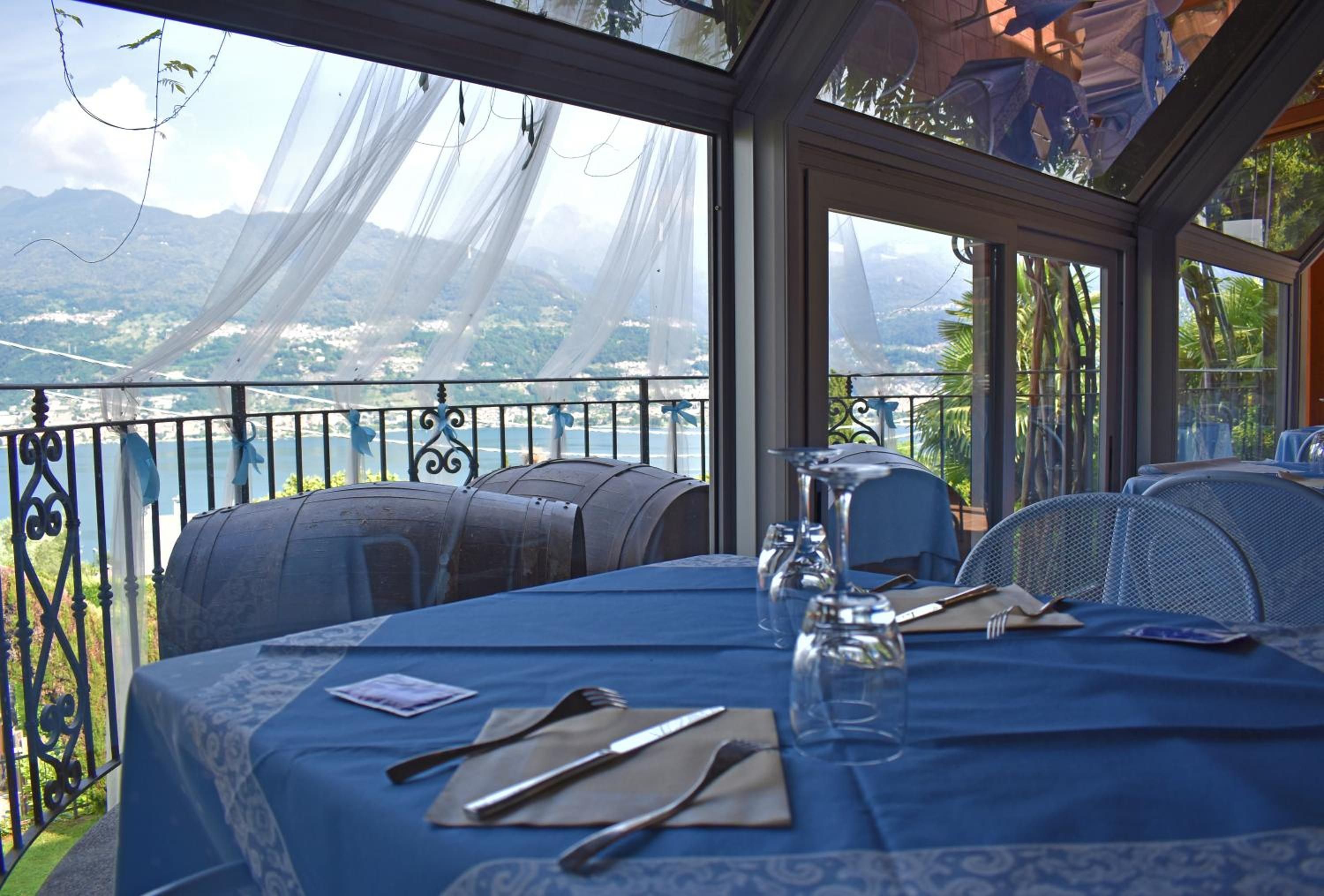 Ein Tisch, gedeckt für ein Essen, mit Blick auf ein Gewässer und Berge.