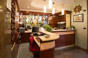 A bar area with shelves of liquor bottles, a coffee machine, and a counter with a plant.