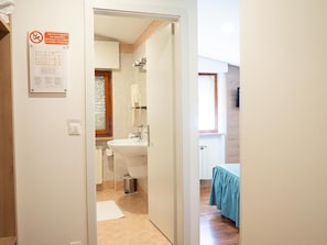 Une salle de bain avec un lavabo, un miroir et une fenêtre.