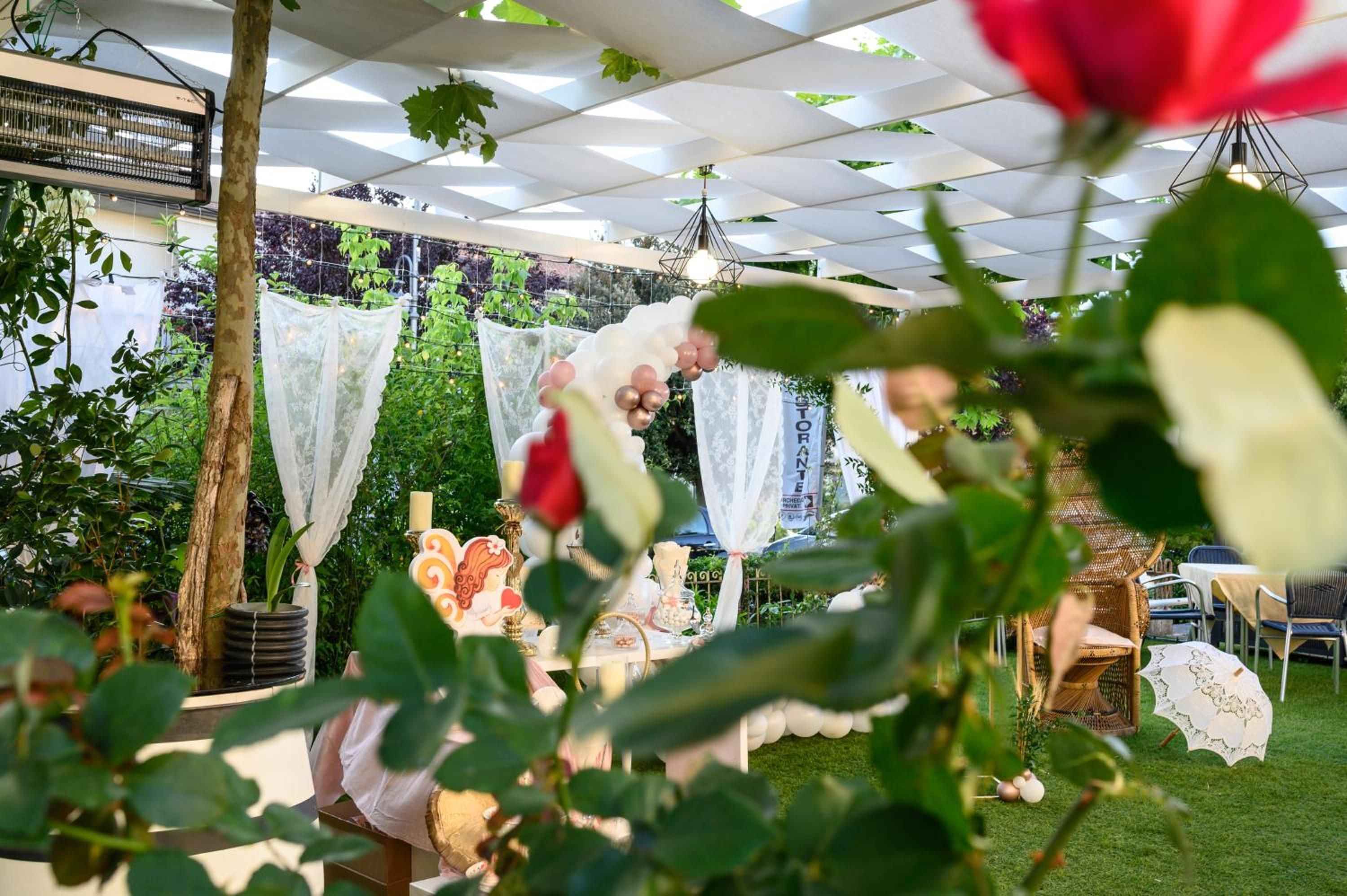 An outdoor event with a tent, tables, chairs, and decorative elements like flowers and banners.