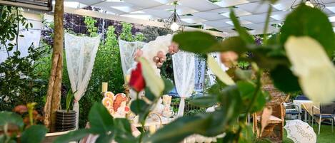 An outdoor event with a tent, tables, chairs, and decorative elements like flowers and banners.