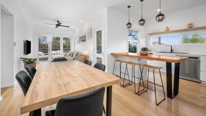 Una cocina moderna con una isla de madera, taburetes de bar e iluminación colgante.