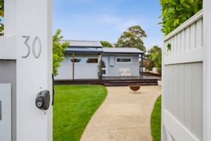 A residential property with a number 30 sign, a white fence, and a pathway leading to a house with a porch. - Comfy Torquay Home - Pet-Friendly, Walk to Beach (Torquay)