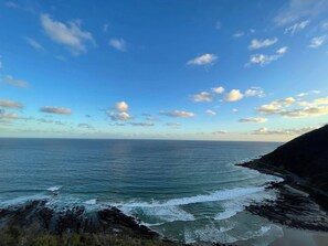 A coastal landscape with a clear sky, calm sea, and rocky shoreline. - Comfy Torquay Home - Pet-Friendly, Walk to Beach (Torquay)