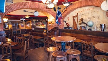 Een gezellig pub interieur met houten meubels, een harp en een muur met muzieknoten.