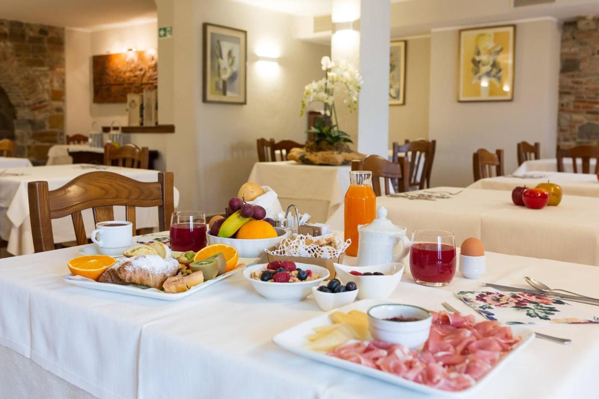 Ein Frühstücksbuffet mit verschiedenen Früchten, Gebäck und Fleischwaren.