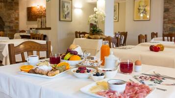 Ein Frühstücksbuffet mit verschiedenen Früchten, Gebäck und Fleischwaren.