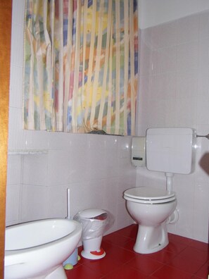 Un baño con inodoro, bidé y lavamanos.