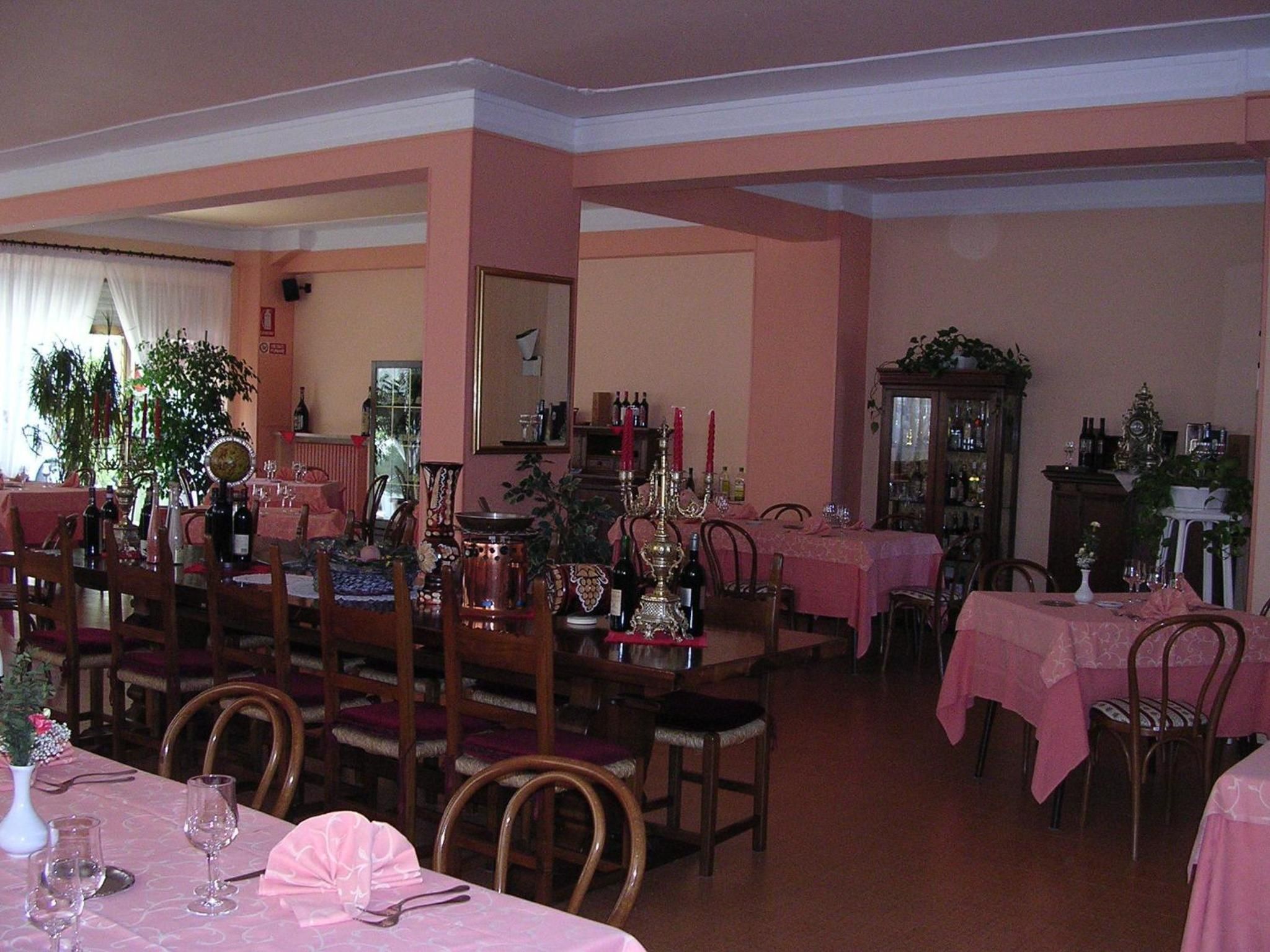 Zona pranzo con diversi tavoli, sedie e vari tipi di tavola apparecchiata.