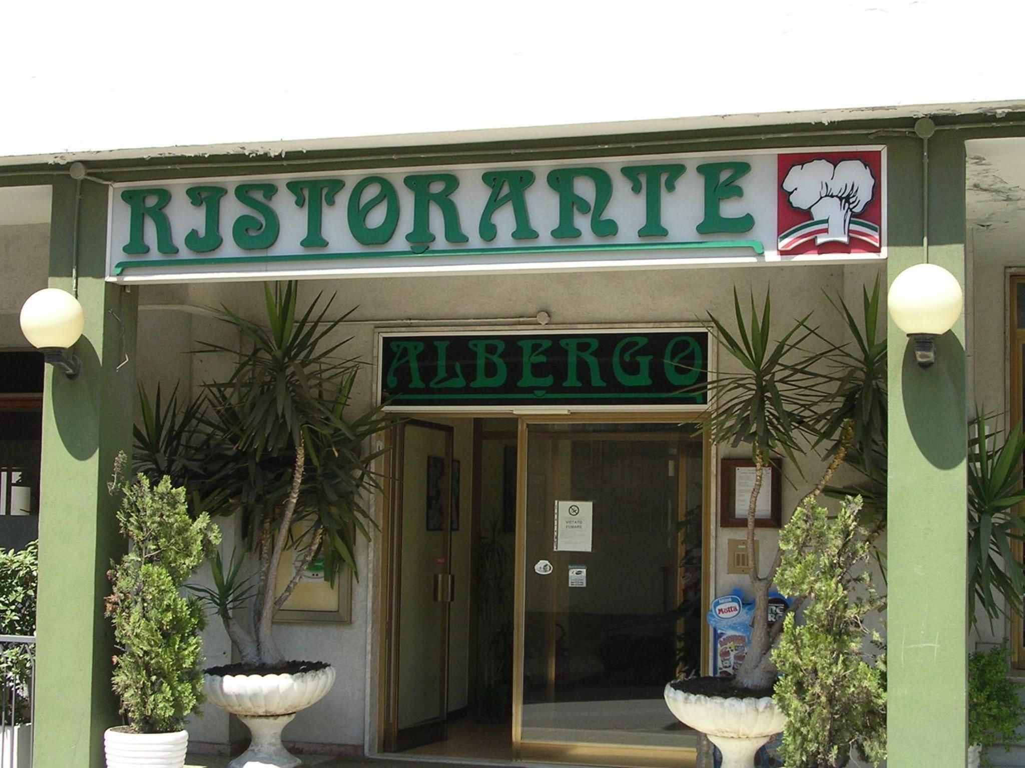 A restaurant named 'Ristorante Albergo' with a sign above the entrance and a logo on the right.