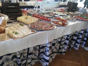 A buffet table with various food items and a white tablecloth. - Ow Meduza I Biala Mewa (Międzyzdroje)