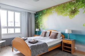 Un dormitorio con cama, dos mesitas de noche, una ventana y un mural en la pared.