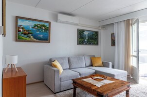 Una sala de estar moderna con un sofá gris, una mesa de centro de madera y dos cuadros en la pared.