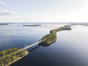 Eine Hängebrücke über einem stillen See mit bewaldeten Inseln.