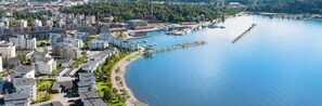 Eine Luftaufnahme einer Küstenstadt mit modernen Gebäuden, einer Marina und einem ruhigen Fluss.