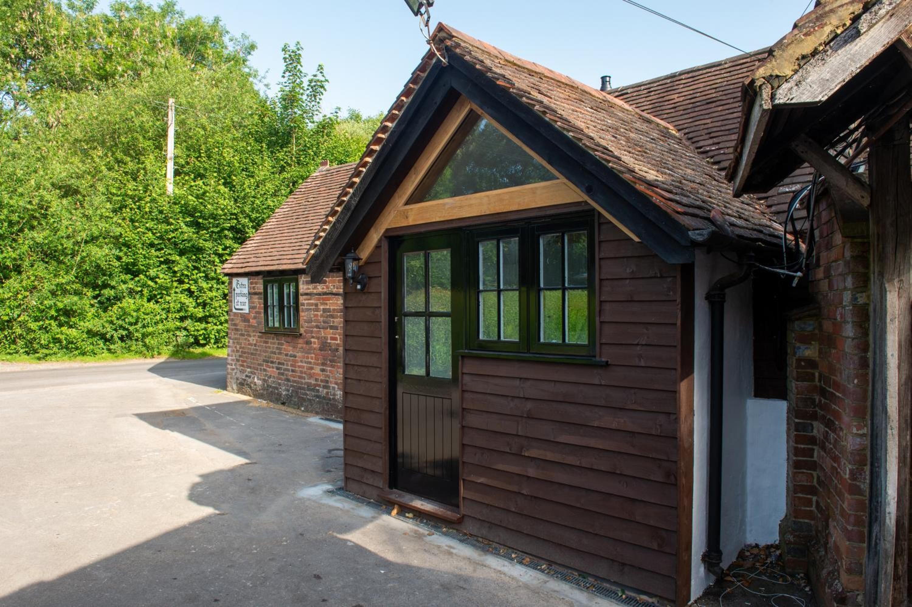 A small, single-story building with a sloped roof, a front door, and a window.