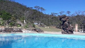 A clear blue pool with a rocky outcrop in the background. - Pousada Chalé Da Montanha São Thomé Das Letras (Sao Thome das Letras)